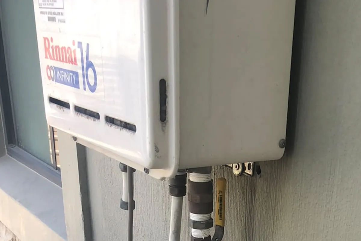 Rinnai Infinity 16 gas geyser wall mounted in open air on a Cape Town home by Red Flame Gas Supplier, with the gas and water lines fitted below